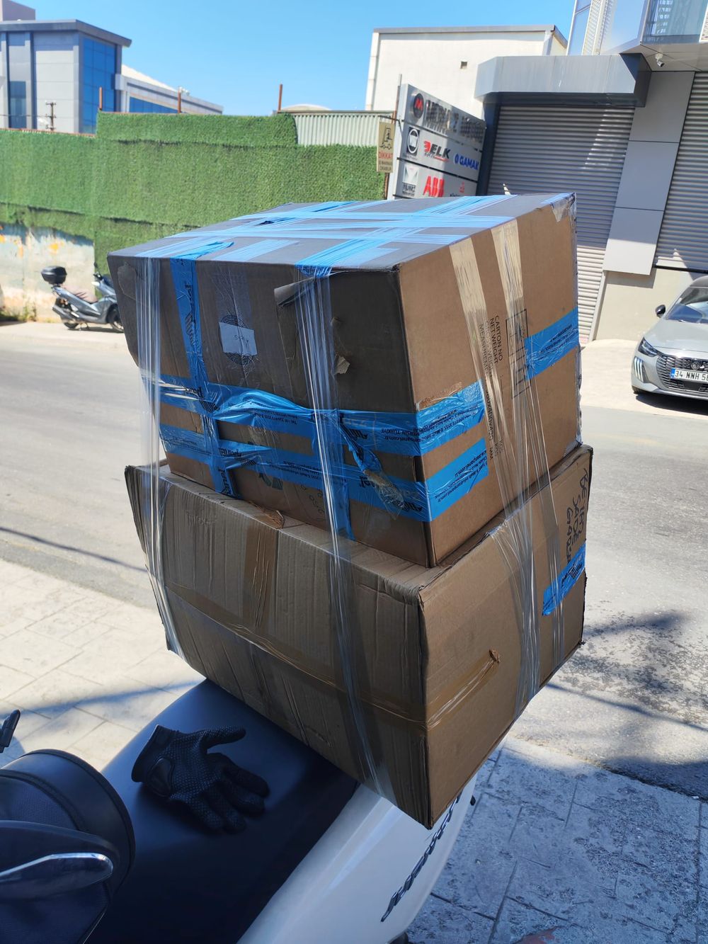 Motosiklet üzerine bantlı ve streç filmle sabitlenmiş koliler, İstanbul sokağında teslimat öncesi