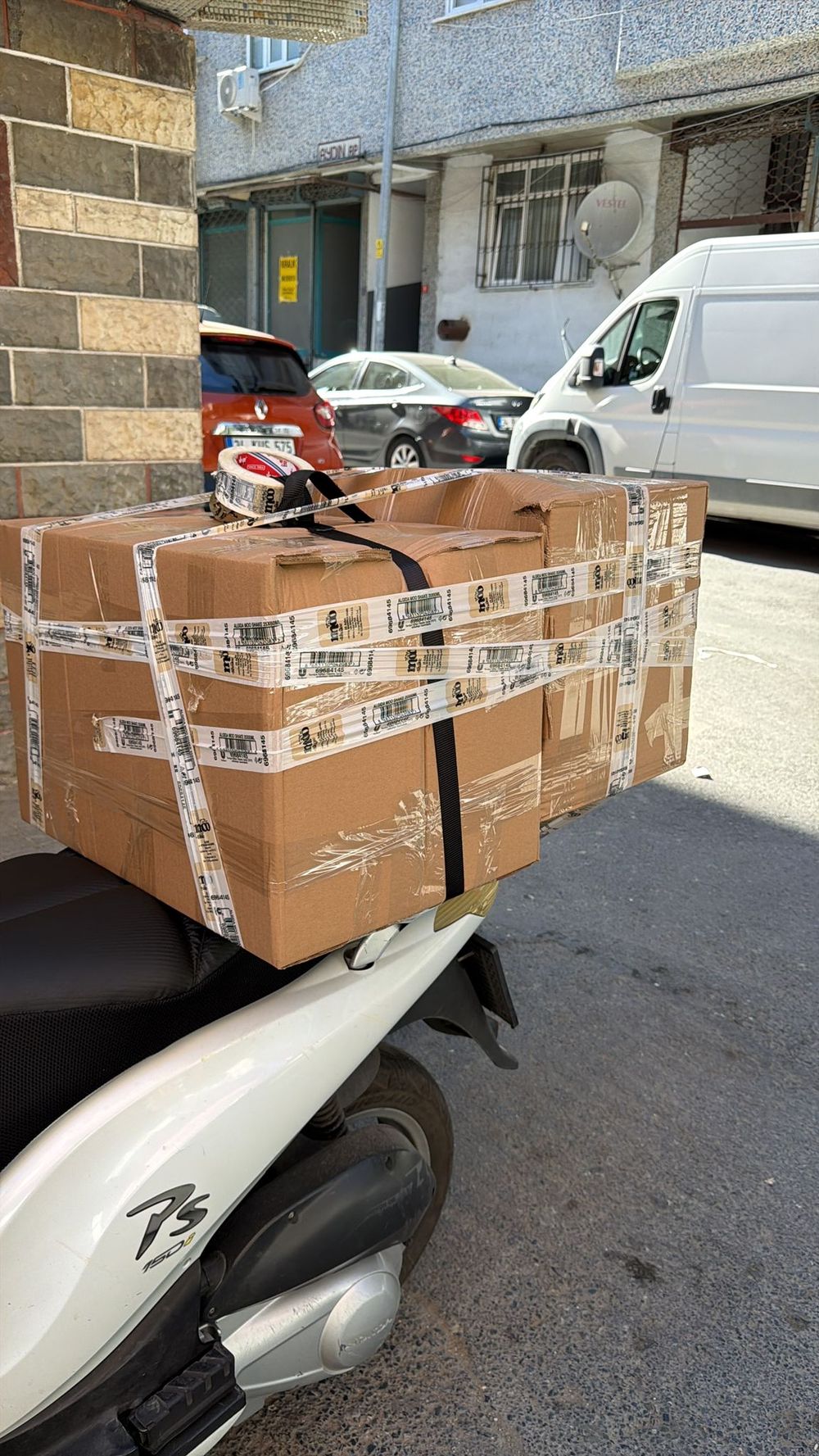 Yetiş Kurye 34 motosikletine emniyet kayışıyla sıkıca bağlanmış paketler